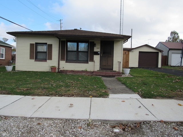 bungalow featuring a front yard, a garage, an outdoor structure, and a porch