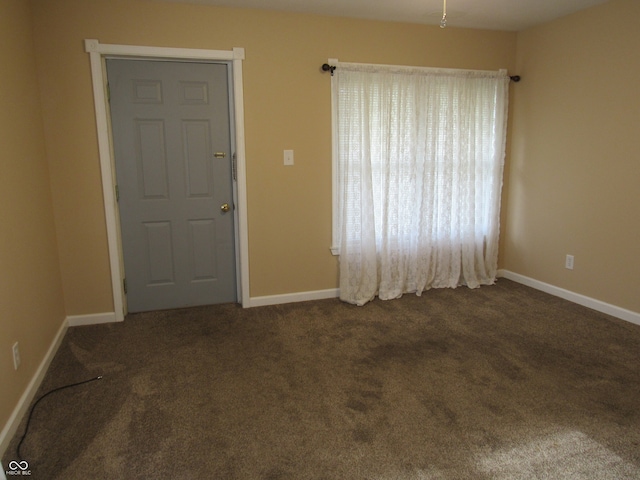 unfurnished room featuring dark colored carpet and ceiling fan