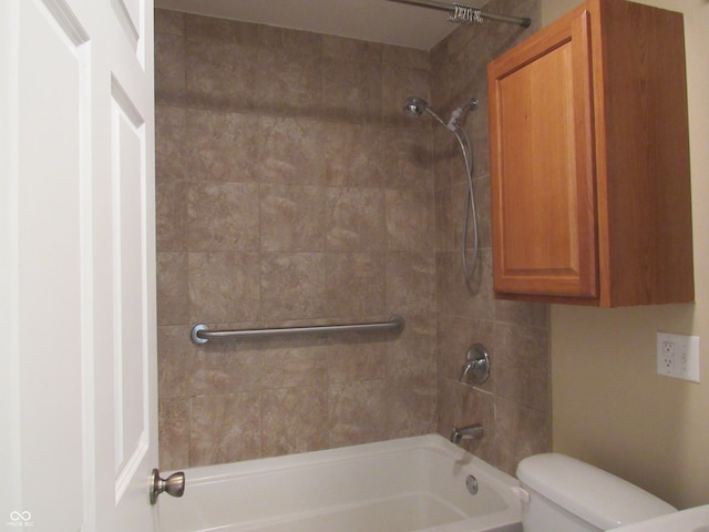 bathroom with toilet and tiled shower / bath