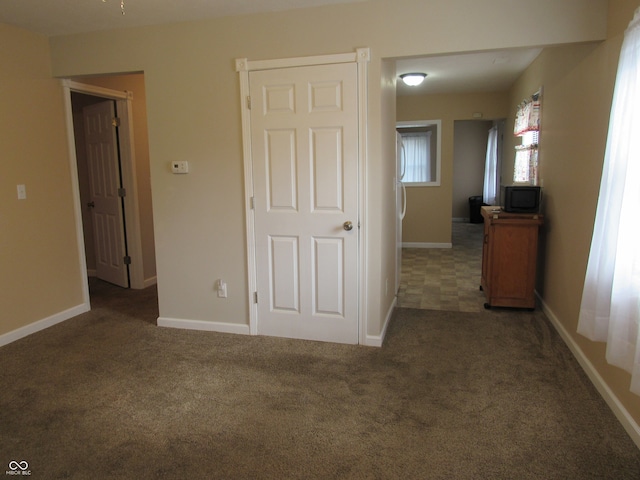 unfurnished bedroom with dark colored carpet