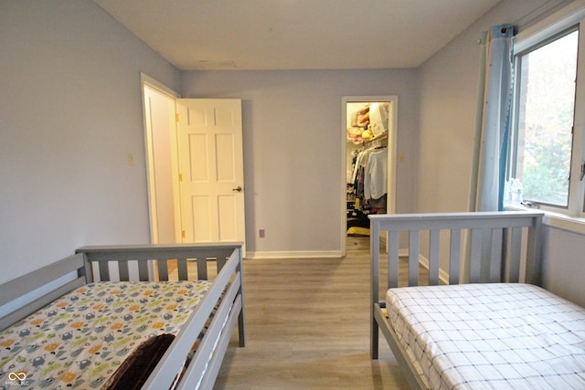 bedroom featuring a closet, light hardwood / wood-style flooring, and a spacious closet