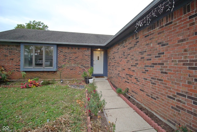 doorway to property featuring a lawn