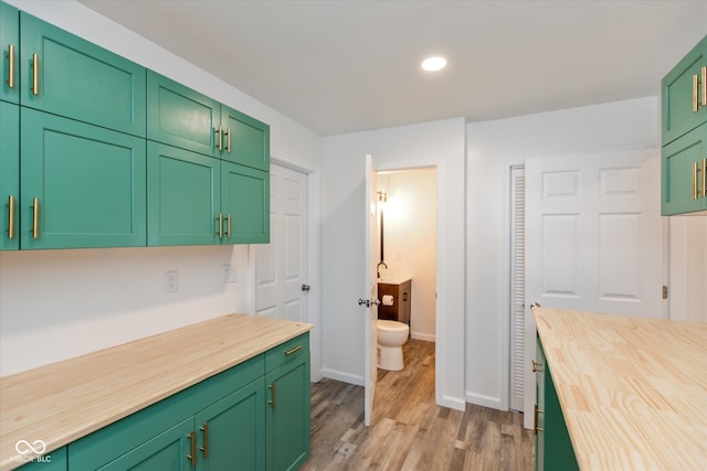 kitchen with butcher block counters, light hardwood / wood-style flooring, and green cabinetry