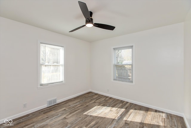 empty room with dark hardwood / wood-style flooring and ceiling fan