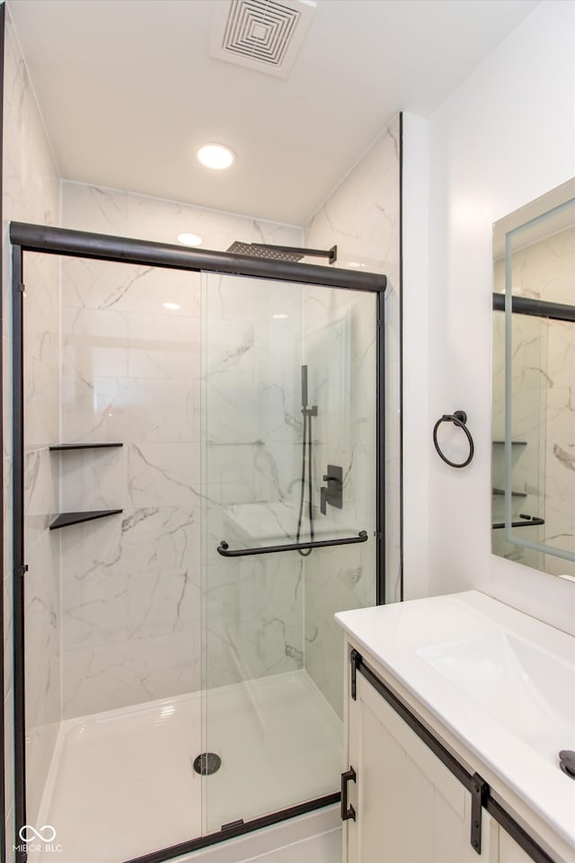 bathroom with vanity and a shower with door