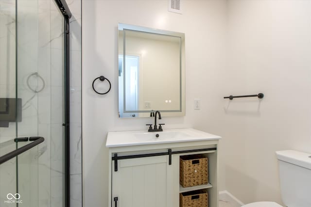 bathroom featuring walk in shower, vanity, and toilet