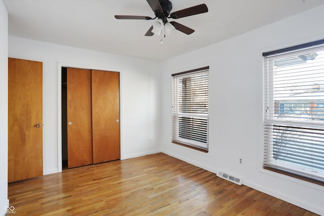 unfurnished bedroom featuring ceiling fan, a closet, and light hardwood / wood-style flooring