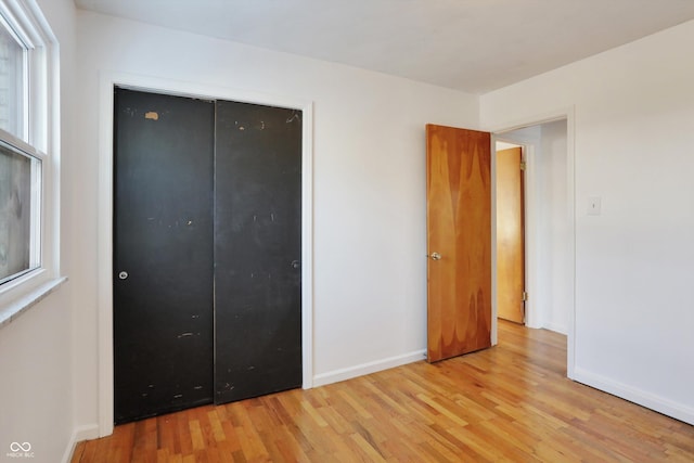 unfurnished bedroom with a closet and light hardwood / wood-style flooring