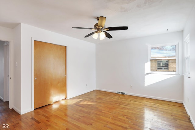 unfurnished bedroom featuring ceiling fan, a closet, and light hardwood / wood-style flooring