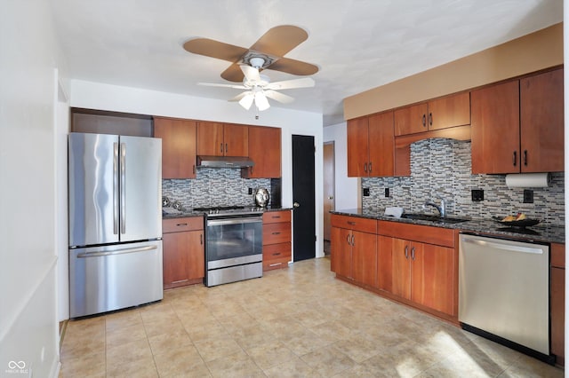 kitchen with stainless steel appliances, decorative backsplash, dark stone countertops, and sink