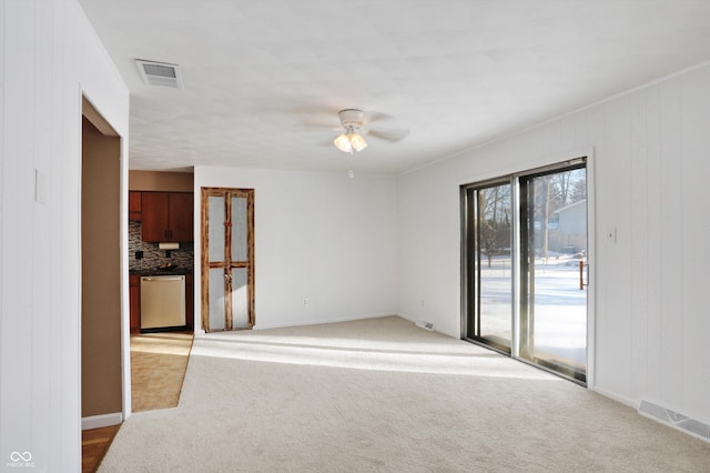 carpeted spare room with ceiling fan