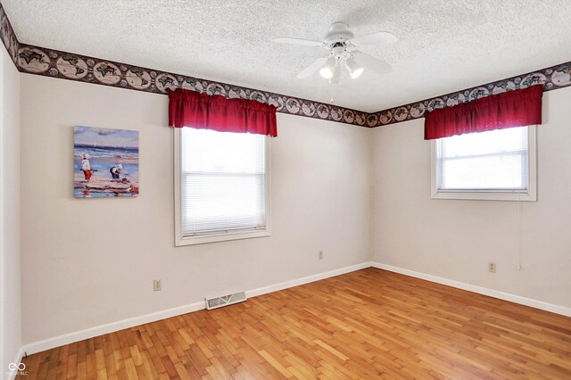 spare room with ceiling fan, hardwood / wood-style floors, and a textured ceiling