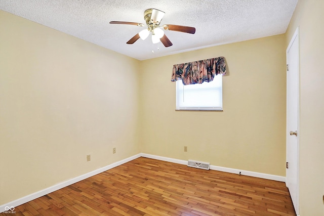 empty room with ceiling fan, a textured ceiling, and hardwood / wood-style floors