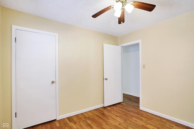 unfurnished bedroom featuring ceiling fan, light hardwood / wood-style floors, and a textured ceiling