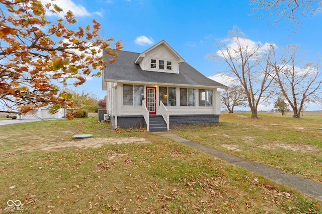 view of front of property featuring central AC unit, a front lawn, and a sunroom