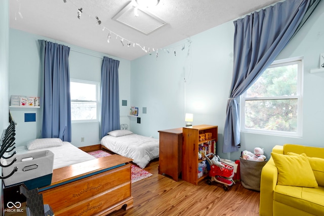 bedroom featuring hardwood / wood-style floors and a textured ceiling