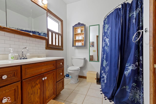 bathroom featuring toilet, vanity, tasteful backsplash, and tile patterned floors