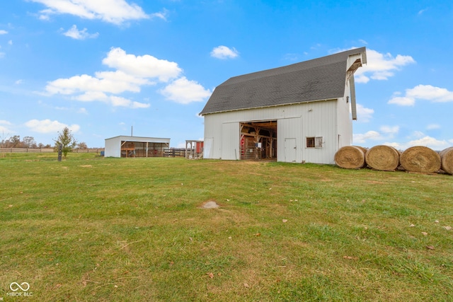 rear view of property with an outbuilding and a yard