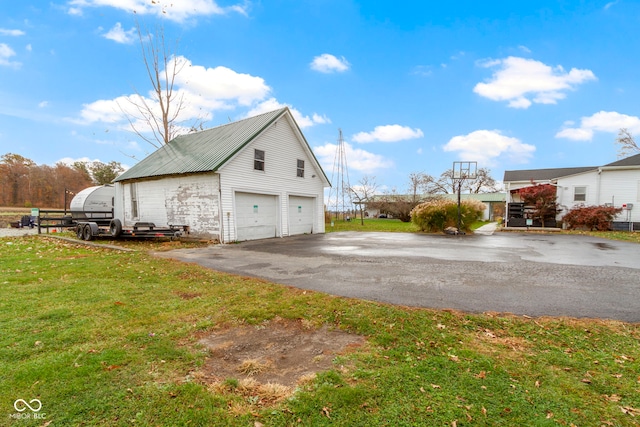 view of side of home featuring a yard, an outbuilding, and a garage