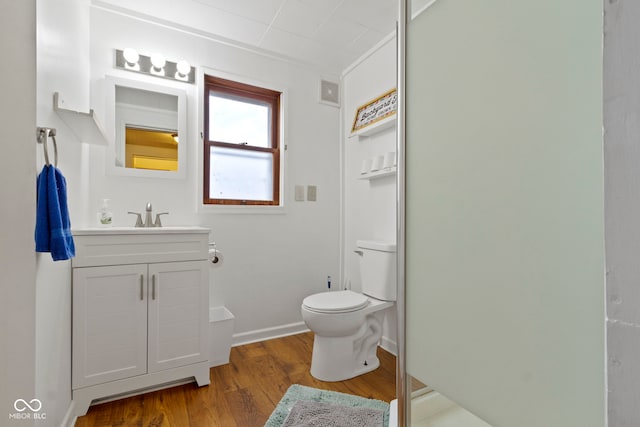 bathroom with hardwood / wood-style flooring, vanity, and toilet