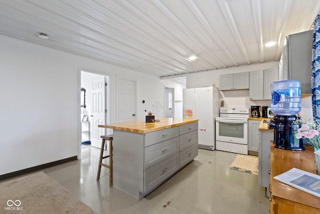 kitchen featuring a center island, white appliances, butcher block countertops, and gray cabinetry