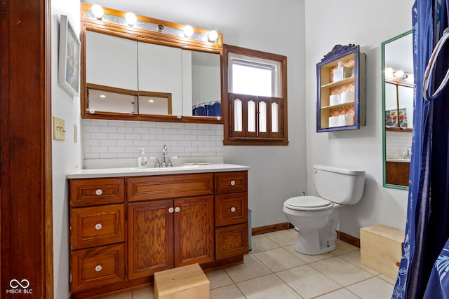 bathroom with tile patterned floors, decorative backsplash, vanity, and toilet