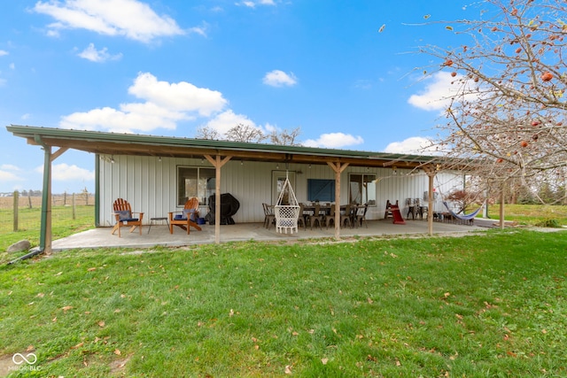 back of property with a yard and a patio