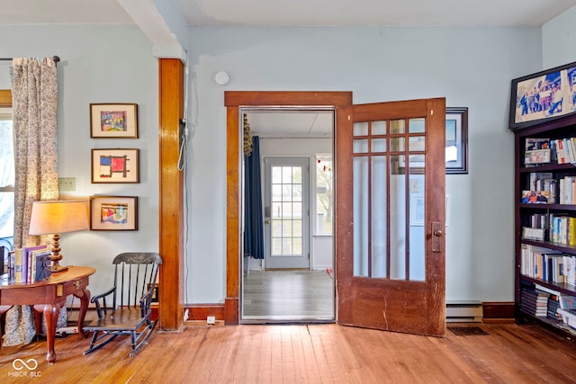 foyer entrance with french doors, hardwood / wood-style flooring, and a baseboard heating unit