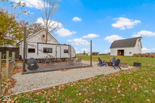 view of yard with a fire pit, an outbuilding, and a deck