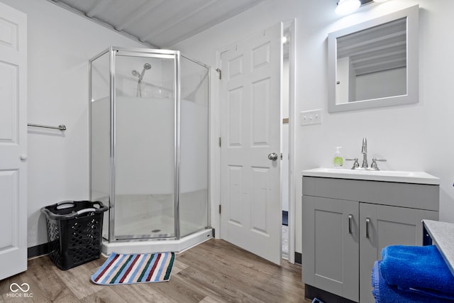 bathroom featuring a shower with door, vanity, and hardwood / wood-style flooring