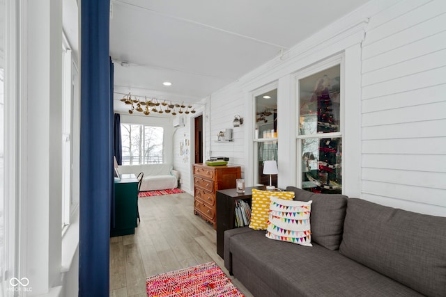 living room with wooden walls and light hardwood / wood-style floors