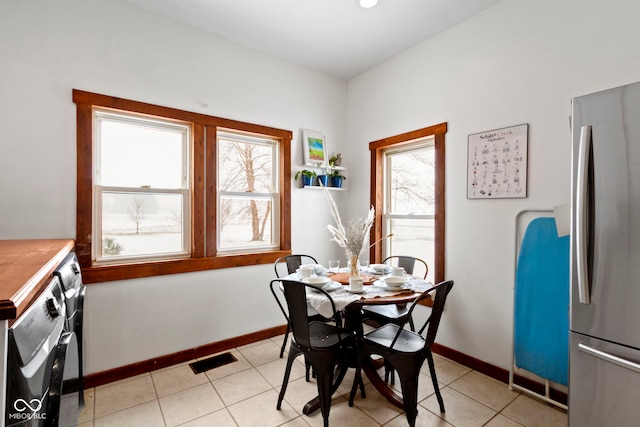 dining room with washer / clothes dryer, a wealth of natural light, and light tile patterned flooring