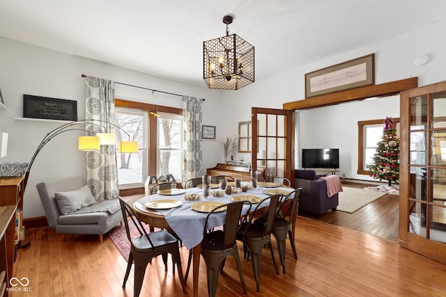 dining area with hardwood / wood-style flooring and an inviting chandelier