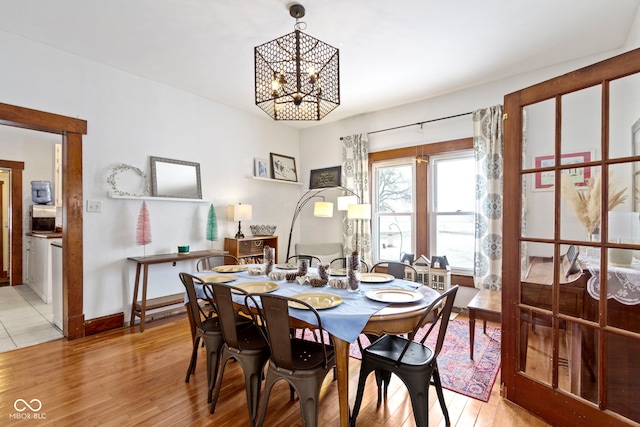 dining space featuring an inviting chandelier and light wood-type flooring