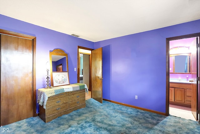 bedroom with ensuite bathroom, a closet, sink, and dark carpet