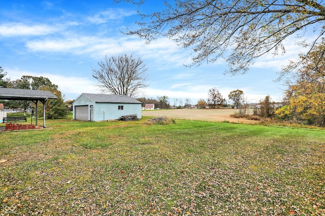 view of yard featuring a garage, a rural view, and an outdoor structure