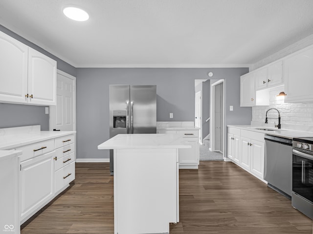 kitchen with a kitchen island, white cabinets, sink, and stainless steel appliances