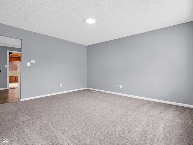 carpeted spare room featuring a textured ceiling