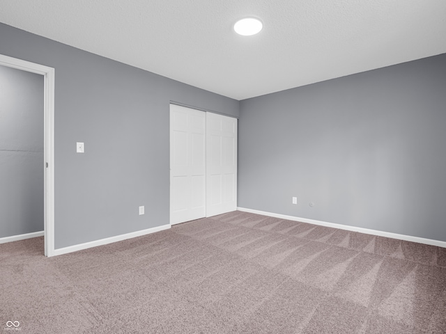 unfurnished bedroom with a closet and carpet flooring