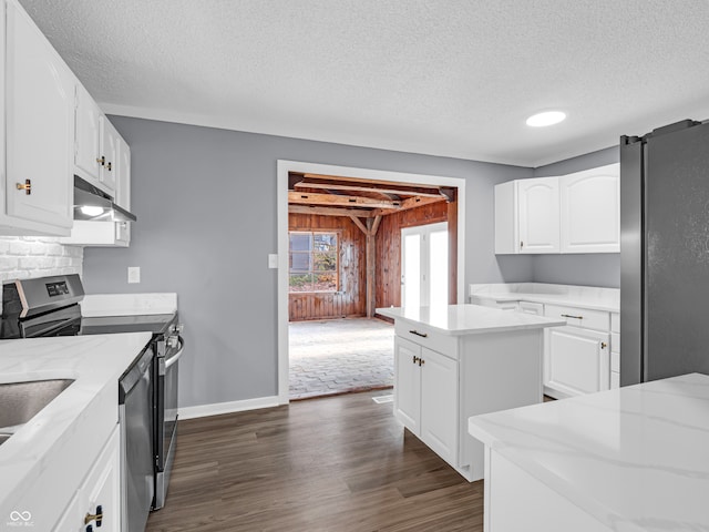 kitchen with stainless steel appliances, white cabinetry, a textured ceiling, a center island, and dark wood-type flooring