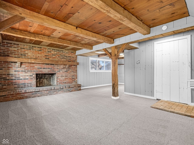 unfurnished living room featuring wooden ceiling, beamed ceiling, carpet, a brick fireplace, and wooden walls