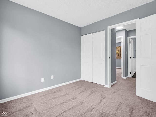 unfurnished bedroom with a closet, a textured ceiling, and carpet flooring