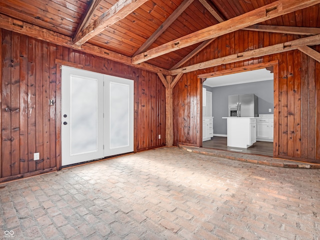 unfurnished living room with wooden walls, wooden ceiling, and vaulted ceiling with beams