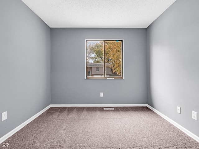 unfurnished room featuring a textured ceiling and carpet floors