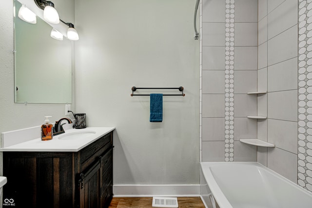 bathroom with tiled shower / bath combo and vanity