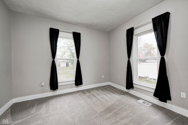 carpeted spare room featuring a textured ceiling