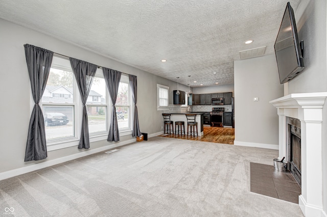 unfurnished living room with a textured ceiling and carpet flooring