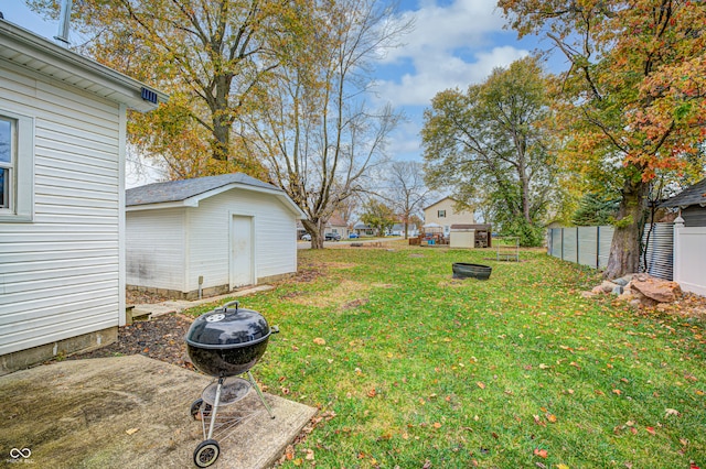 view of yard with an outdoor fire pit and a storage unit