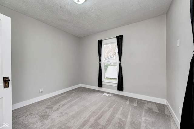 unfurnished room with a textured ceiling and carpet