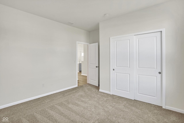 unfurnished bedroom featuring carpet and a closet